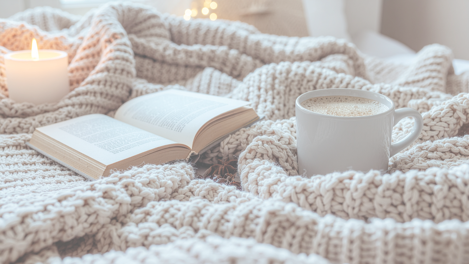 Cozy scene with a knit blanket, open book, candle, and coffee mug for calm, mindful living